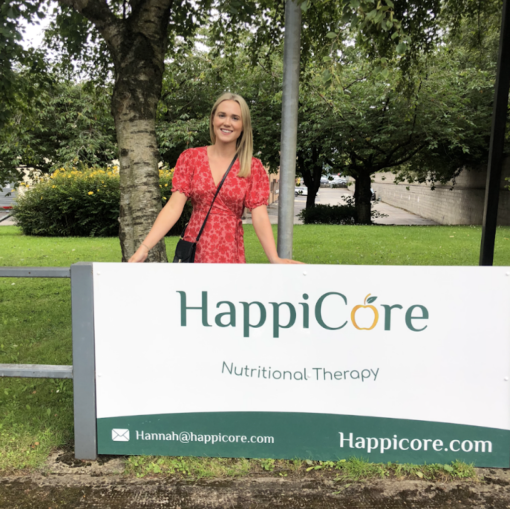 picture of the happicore road sign with owner standing behind